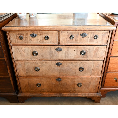 89 - An 18th century and later oak and walnut chest of two short over three long drawers on bracket feet,... 