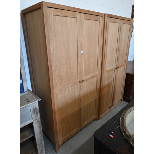 94 - # Two modern light oak wardobes, the twin panelled doors enclosing hanging rails, 100 cm w x 60 cm d... 