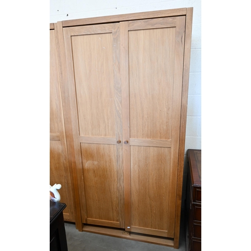 94 - # Two modern light oak wardobes, the twin panelled doors enclosing hanging rails, 100 cm w x 60 cm d... 