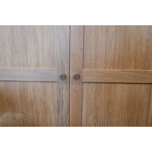 94 - # Two modern light oak wardobes, the twin panelled doors enclosing hanging rails, 100 cm w x 60 cm d... 