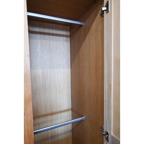 94 - # Two modern light oak wardobes, the twin panelled doors enclosing hanging rails, 100 cm w x 60 cm d... 