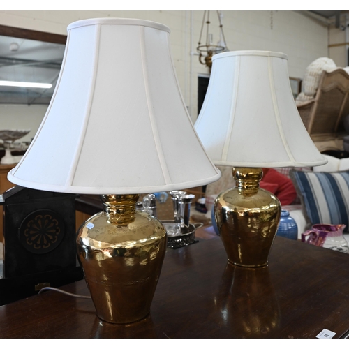 259 - A pair of hammered brass table lamps c/w shades, 56 cm high