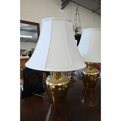 259 - A pair of hammered brass table lamps c/w shades, 56 cm high