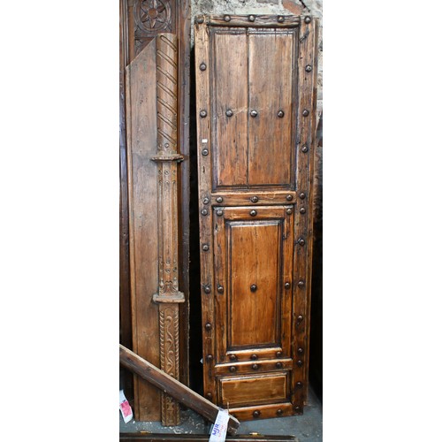 281 - A large architectural carved Indian hardwood door frame with a pair of associated doors and with an ... 