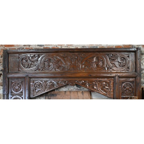 281 - A large architectural carved Indian hardwood door frame with a pair of associated doors and with an ... 