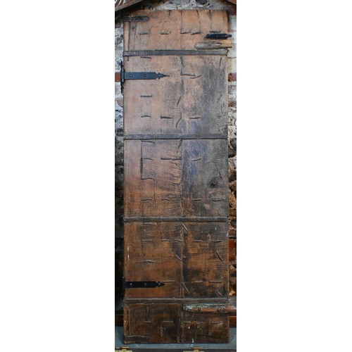 281 - A large architectural carved Indian hardwood door frame with a pair of associated doors and with an ... 