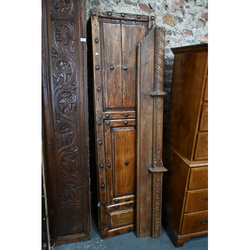 281 - A large architectural carved Indian hardwood door frame with a pair of associated doors and with an ... 