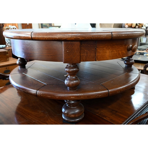 82 - A large stained oak circular coffee table with two drawers and open under-tier, raised on turned sup... 