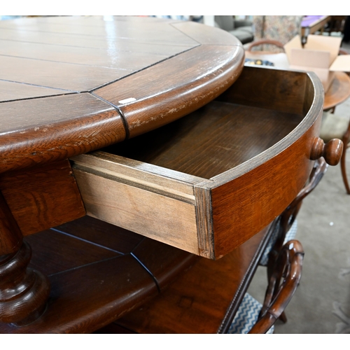 82 - A large stained oak circular coffee table with two drawers and open under-tier, raised on turned sup... 