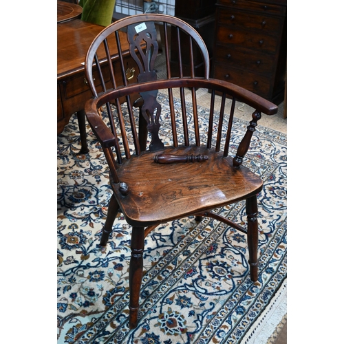 50 - A 19th century yew and elm Windsor hoop back elbow chair, raised on turned legs united by a crinolin... 