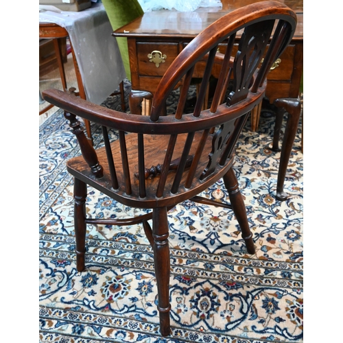 50 - A 19th century yew and elm Windsor hoop back elbow chair, raised on turned legs united by a crinolin... 