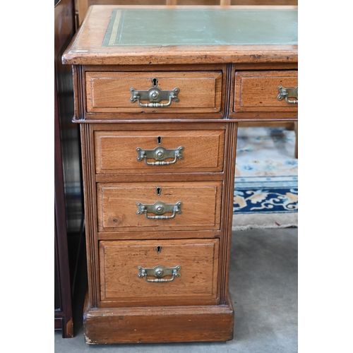 116 - A late 19th or early 20th century oak twin pedestal desk with gilt tooled green leather top over nin... 