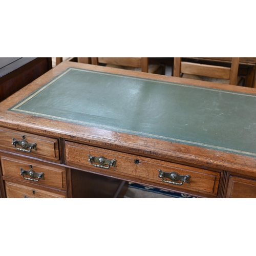 116 - A late 19th or early 20th century oak twin pedestal desk with gilt tooled green leather top over nin... 