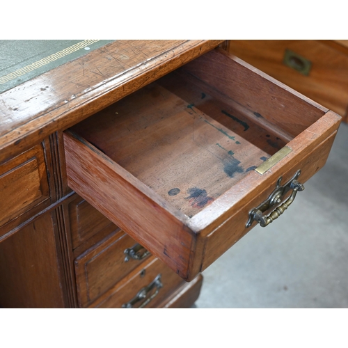 116 - A late 19th or early 20th century oak twin pedestal desk with gilt tooled green leather top over nin... 