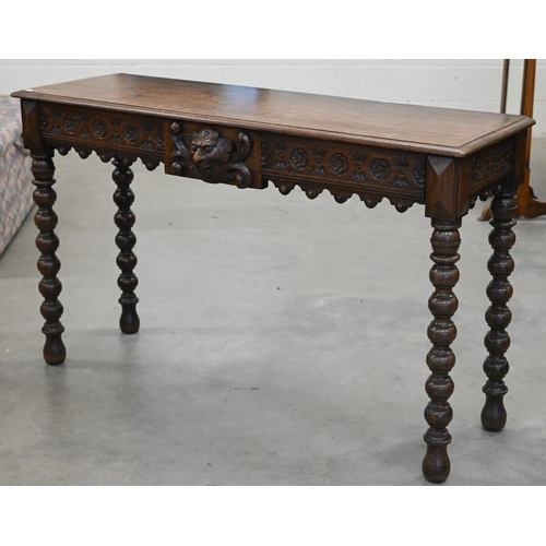 132 - A late Victorian Gothic revival carved oak console table with central lion mask motif between two dr... 