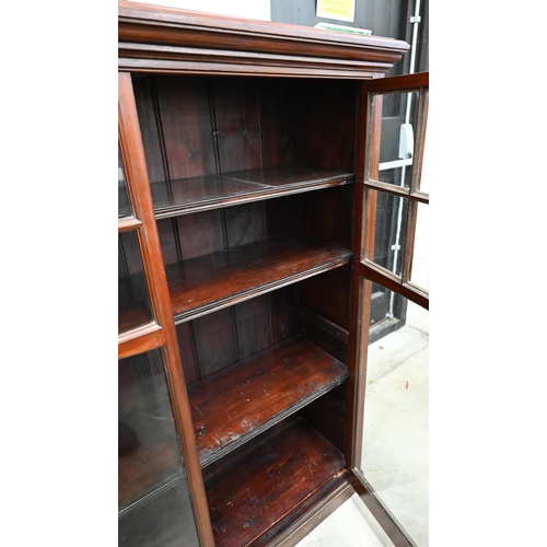 143 - An Edwardian mahogany library bookcase with two glazed doors enclosing three shelves, raised on plin... 