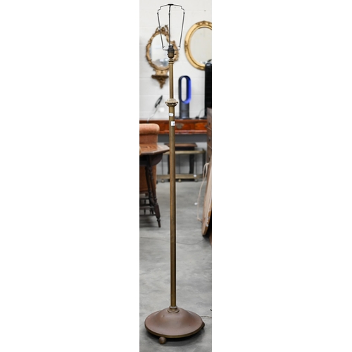 151 - An adjustable brass standard lamp with circular platform base on ball feet