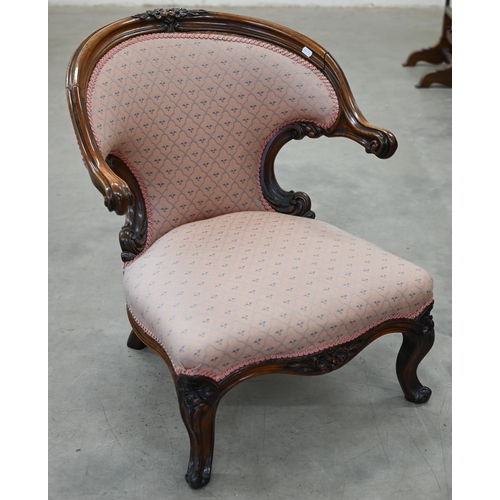 154 - A Victorian walnut framed nursing chair with floral carving, upholstered in pink fabric with repeati... 