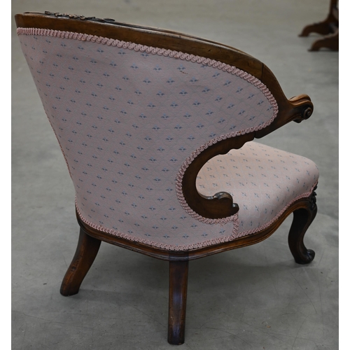 154 - A Victorian walnut framed nursing chair with floral carving, upholstered in pink fabric with repeati... 