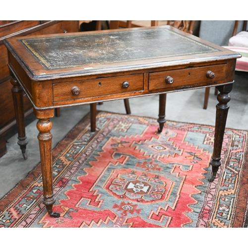 155 - A Victorian oak writing table with gilt tooled leather top and two drawers raised on turned fluted s... 