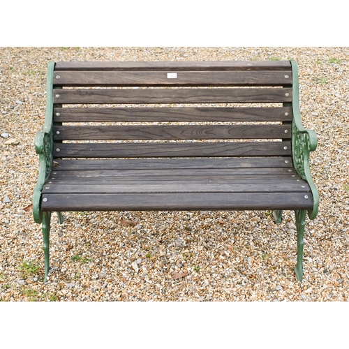 16 - A Victorian style two seat garden bench with cast iron ends and teak slats