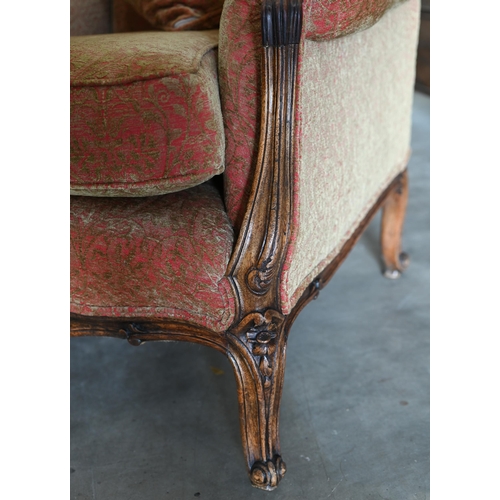 166 - An antique French carved walnut armchair upholstered in old gold and terracotta floral fabric, 82 cm... 