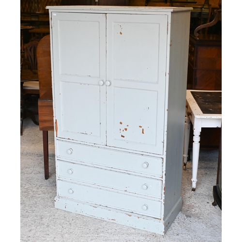 21 - A painted pine two door dwarf wardrobe with three long graduated drawers beneath, on a plinth base 9... 