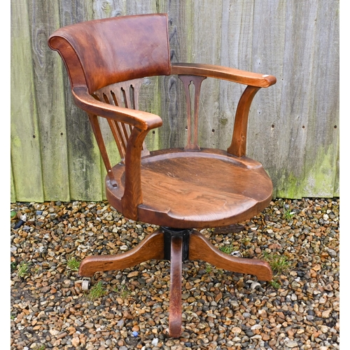 23 - An antique swivel and reclining oak desk chair, with brown leather backrest