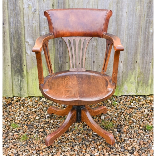 23 - An antique swivel and reclining oak desk chair, with brown leather backrest