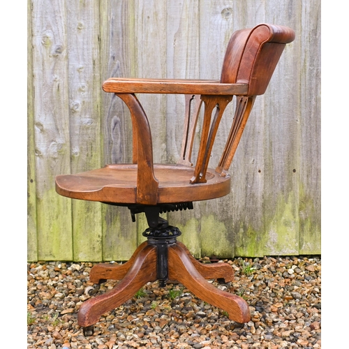 23 - An antique swivel and reclining oak desk chair, with brown leather backrest