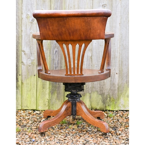 23 - An antique swivel and reclining oak desk chair, with brown leather backrest