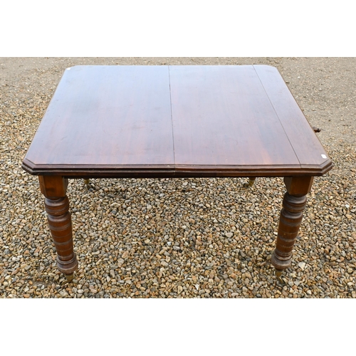 31 - A Edwardian walnut wind out extending dining table with single leaf, raised on turned legs to castor... 