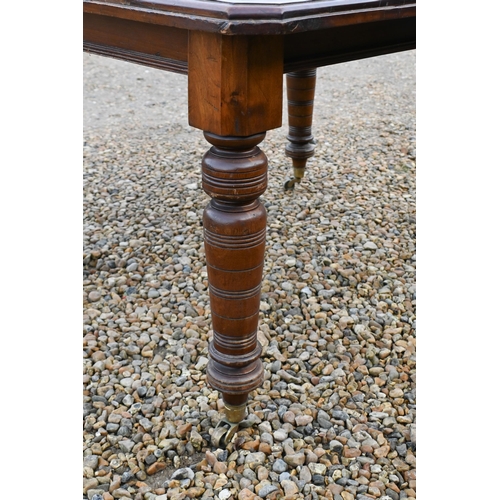 31 - A Edwardian walnut wind out extending dining table with single leaf, raised on turned legs to castor... 