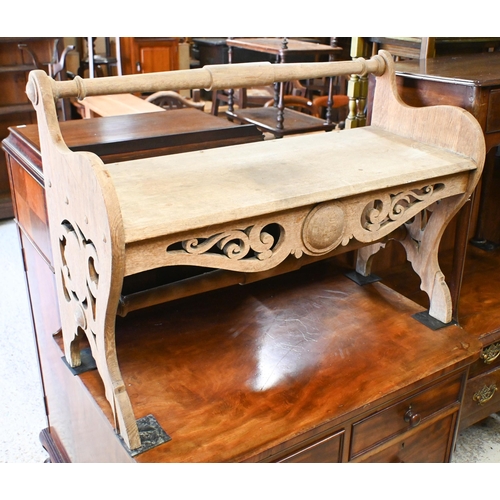 33 - An Arts & Crafts period oak bench seat, the turned back rail over fret cut ends and conforming s... 