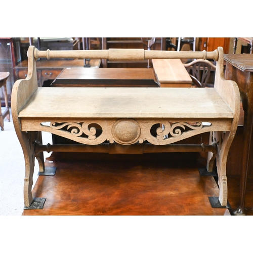 33 - An Arts & Crafts period oak bench seat, the turned back rail over fret cut ends and conforming s... 