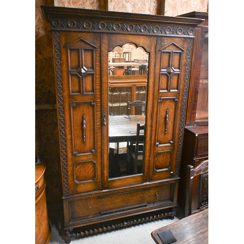 41 - An antique oak wardrobe, with single mirror panelled door flanked by moulded fixed panels, with full... 