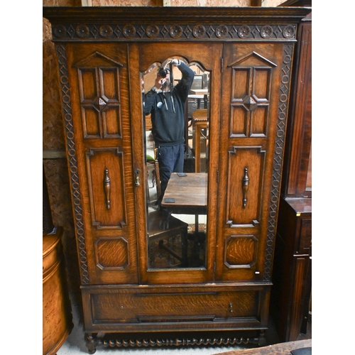 41 - An antique oak wardrobe, with single mirror panelled door flanked by moulded fixed panels, with full... 