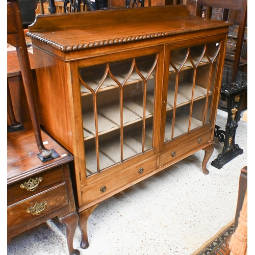 44 - A vintage Gillows style low mahogany two door astragal glazed dwarf bookcase, with two base drawers,... 