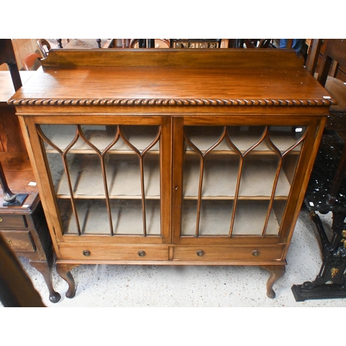 44 - A vintage Gillows style low mahogany two door astragal glazed dwarf bookcase, with two base drawers,... 