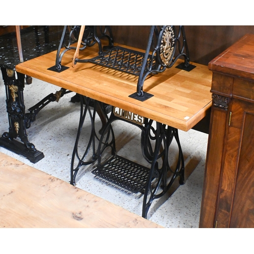 53 - An antique cast iron Jones sewing machine treadle base, converted to a solid oak top table 106 cm w ... 