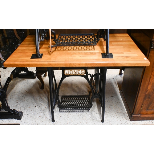 53 - An antique cast iron Jones sewing machine treadle base, converted to a solid oak top table 106 cm w ... 