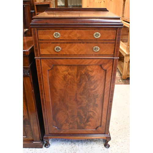 58 - An Edwardian inlaid satinwood music cabinet, with two drawers over a cabinet door enclosing multiple... 