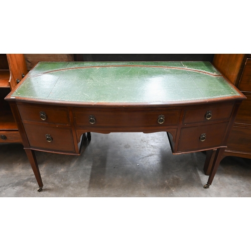 72 - An Edwardian mahogany bowfront writing table with gilt tooled green leather top and three drawers on... 