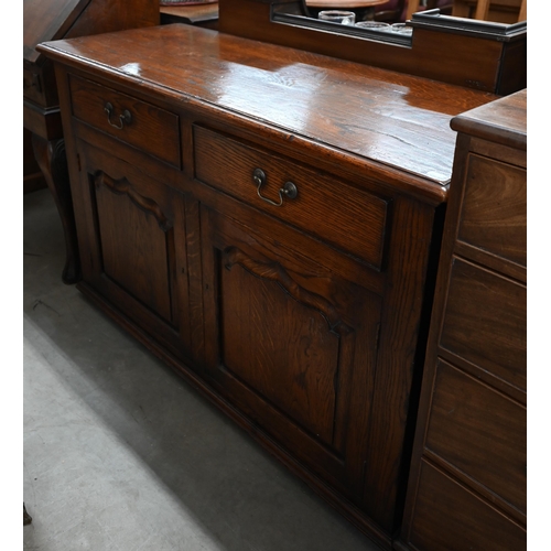 83 - A Cornish reproduction oak sideboard with two drawers over panelled cupboard doors, 122 cm w x 46 cm... 