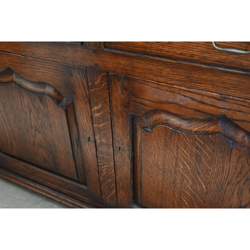 83 - A Cornish reproduction oak sideboard with two drawers over panelled cupboard doors, 122 cm w x 46 cm... 