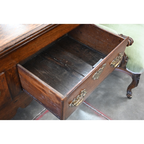 86 - A Georgian 18th century oak low dresser, the two drawers with brass handles over shaped fret-cut apr... 