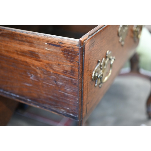 86 - A Georgian 18th century oak low dresser, the two drawers with brass handles over shaped fret-cut apr... 