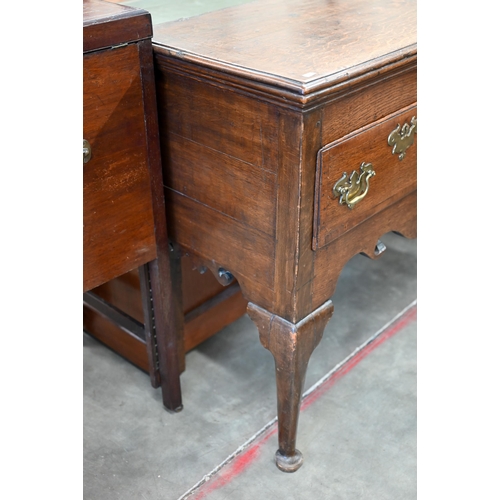 86 - A Georgian 18th century oak low dresser, the two drawers with brass handles over shaped fret-cut apr... 