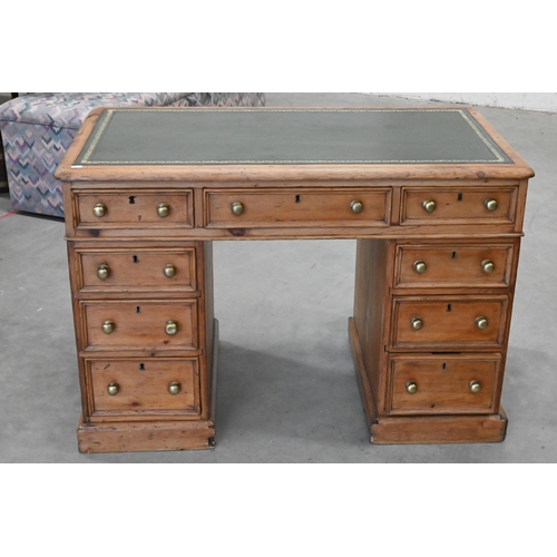 89 - An early 20th century small pine twin pedestal desk with tooled green leather top over nine drawers,... 