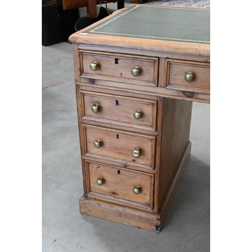 89 - An early 20th century small pine twin pedestal desk with tooled green leather top over nine drawers,... 